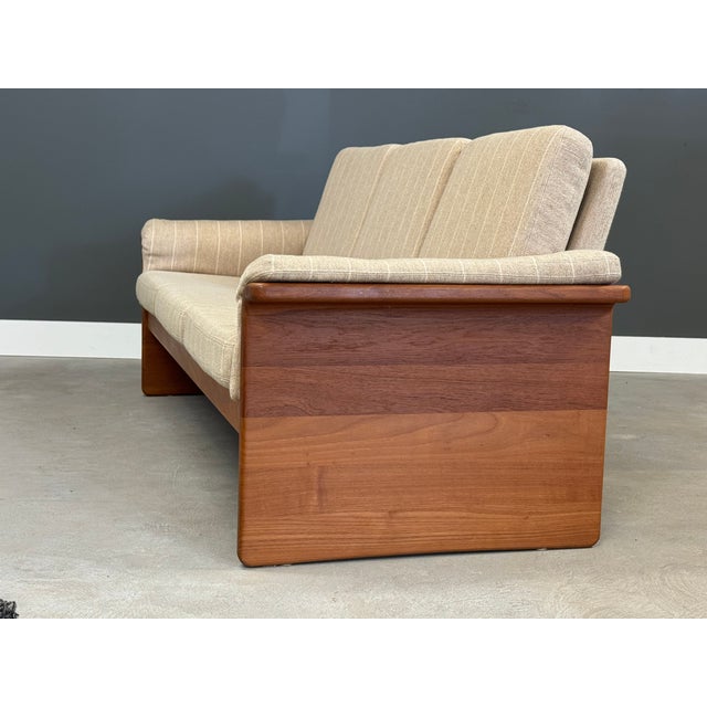 A beige sofa made by EMC Møbler with teak plank sides and flared arms. Made in Denmark. Circa 1980’s. Excellent original...