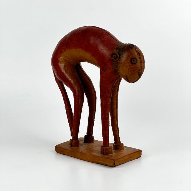 An adorable vintage, one of a kind folk art monkey made of stitched leather with a painted on face. It's very finely made...