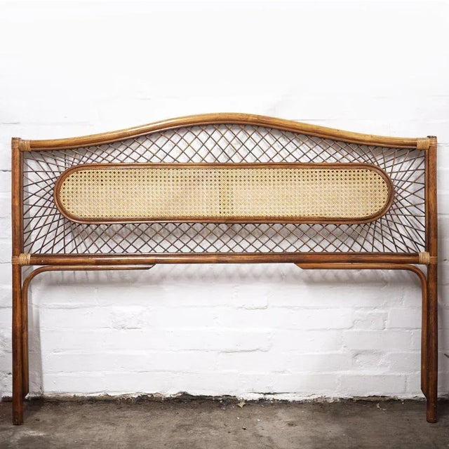 A decorative vintage bamboo and rattan double headboard. This piece is attributed to the mentioned designer/maker. It has...