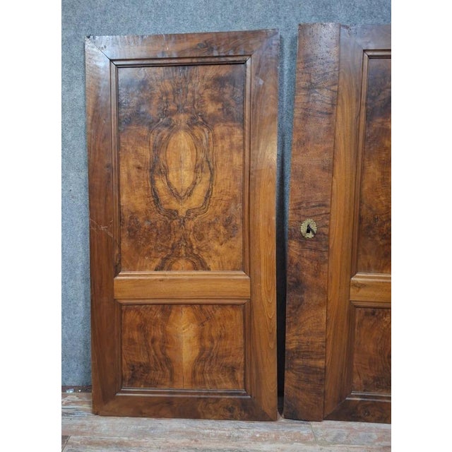 Pair of solid walnut and burr walnut veneer doors. featuring an elegant symmetrical design with particularly decorative...