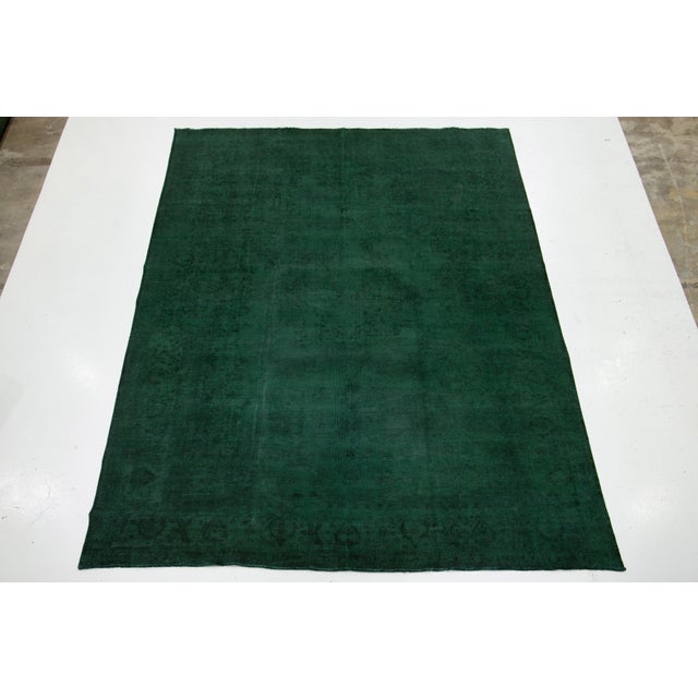 This vintage hand-knotted wool Persian rug showcases a vibrant green field. It features a captivating all-over floral...