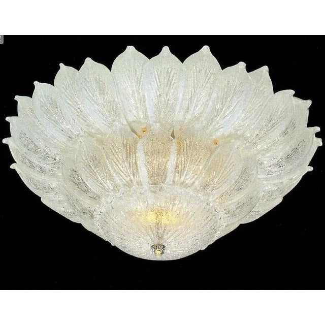 Realized in pure Murano glass consists of an incredible number of leaves. The structure is gilt-metal. 18 lights spread a...
