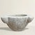 An 18th-century French carved marble mortar, rich with history and softened by centuries of use, its surface worn smooth...