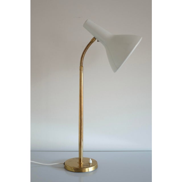 1950s Table Lamp by Harald Notini for Arvid Böhlmarks Lampfabrik, Stockholm, Sweden. Adjustable arm in brass with a white...