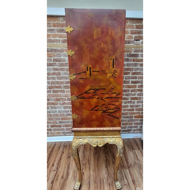 Absolutely Stunning! This cabinet features hand painted artwork and golden detailing around the edges, red wooden in color