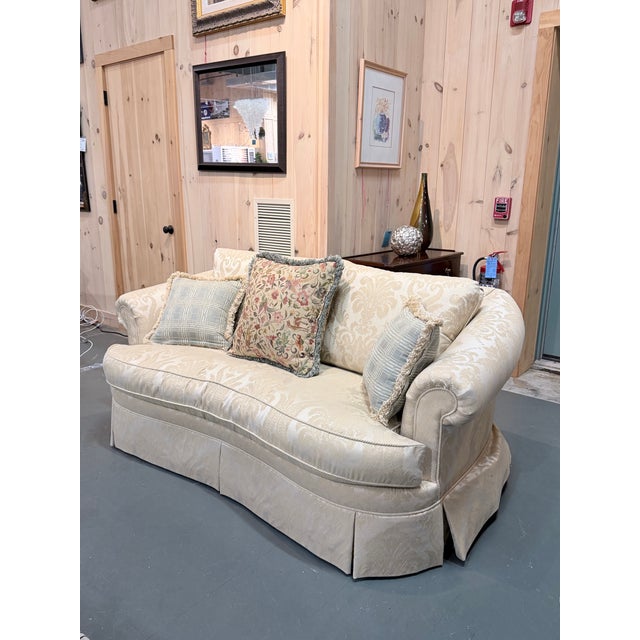 A beautifully tailored vintage Ethan Allen sofa upholstered in an elegant cream damask fabric, offering a refined...