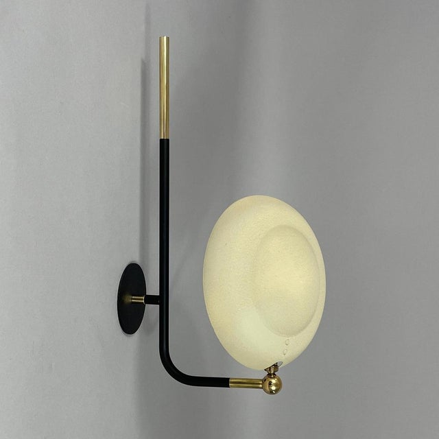 This wall light was designed and manufactured in france in the 1950s. It has a minimalist, modernist design, typical of...