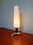 Tripod table lamp in brass and teak with a tubular shade in satin white opaline glass, Scandinavian design, 1960s. The...