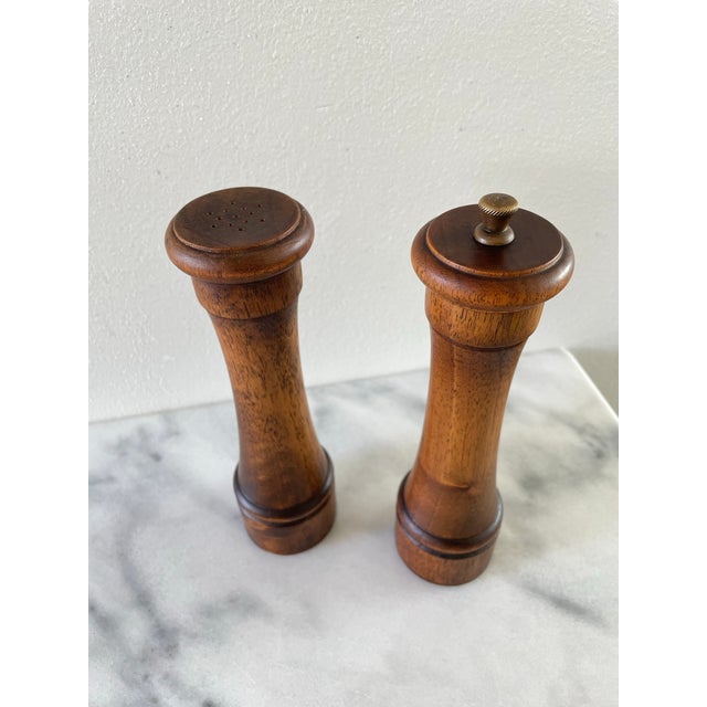 A set of rustic Italian salt shaker and pepper mill, marked made in Italy and crafted from solid dark hardwood. Pepper...