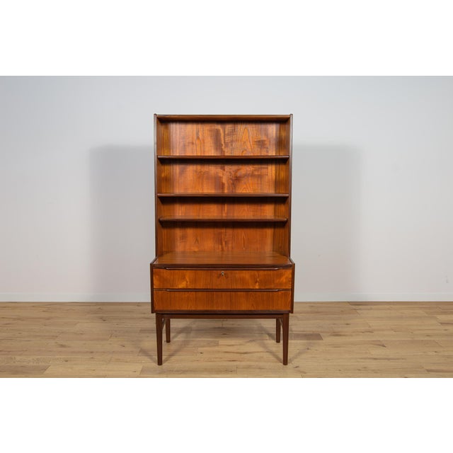 Teak wood shelf made in Denmark in the 1960s. In the upper part there are four open shelves, at the bottom there are two...