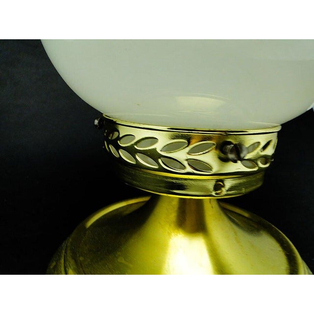 The pendant lamp was produced in the 70s. The structure is made of brass and the lampshade is made of glass. It is...
