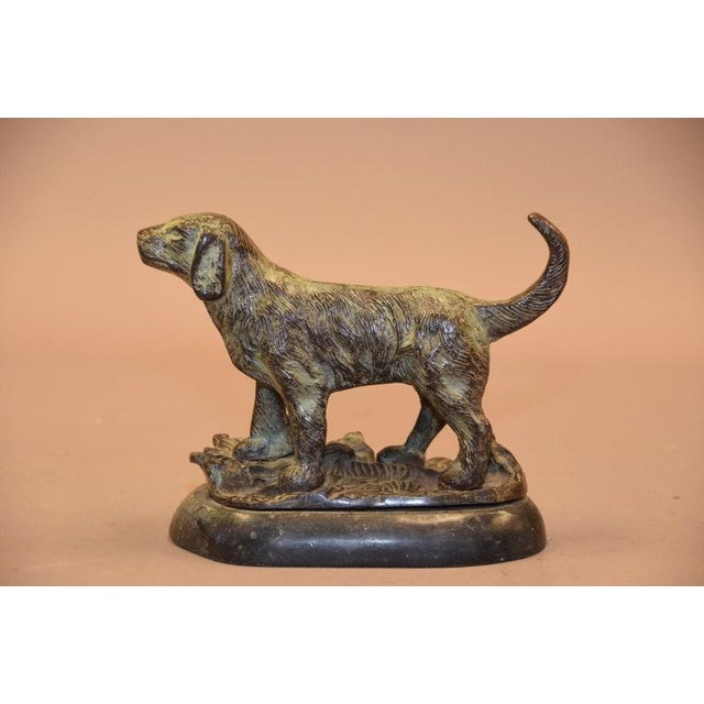 The standing dog, alert and poised on a naturalistic base, was a favorite subject for decorative bronze sculptors well...