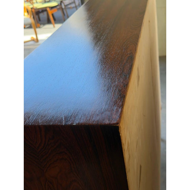 Elegant Danish Mid-Century Modern bookcase crafted in richly grained rosewood. This vintage shelving unit showcases...