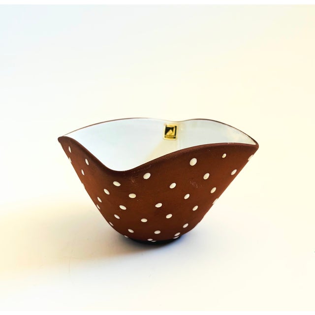 A mid century pottery bowl by Graveren Norsk. Terra cotta exterior with hand painted white dots. Glossy white interior...