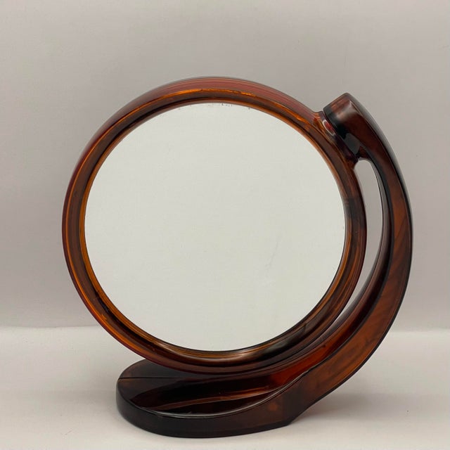 A beautiful brown translucent plastic mirror with magnifying glass on one side and a traditional mirror on the other. Can...