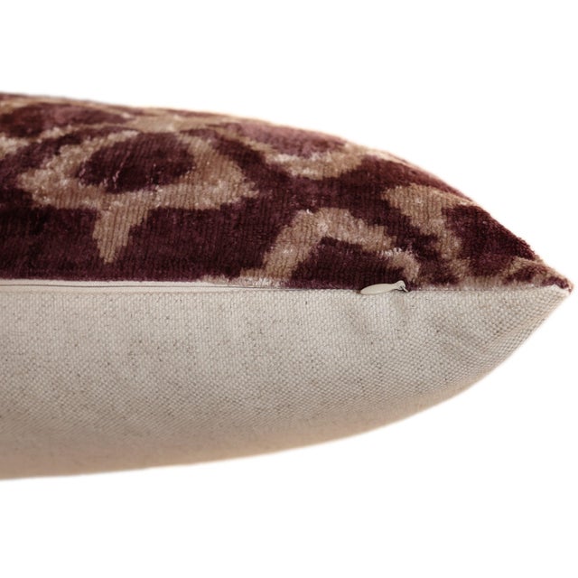 "Elevate any refined space with this handmade silk velvet ikat pillow, showcasing a rich mulberry tone paired with a soft...