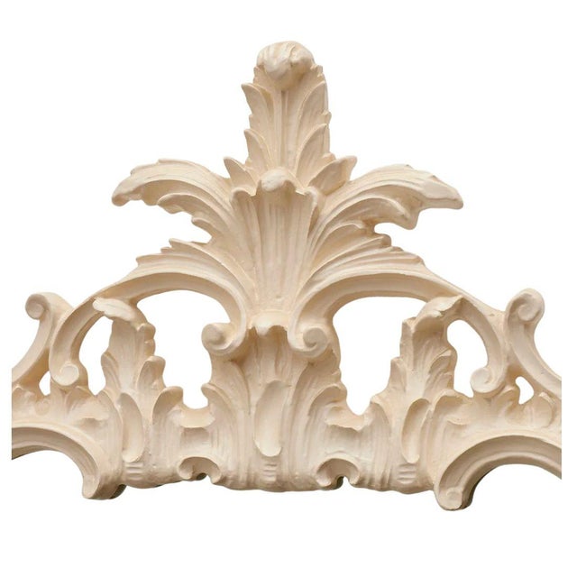 A vintage Louis XV style cream lacquer wall mirror features an intricately molded frame with flowing acanthus leaves,...