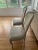 Pair of French Style Provincial side chairs with light gray silk damask newly upholstered with white brocade trim. These...