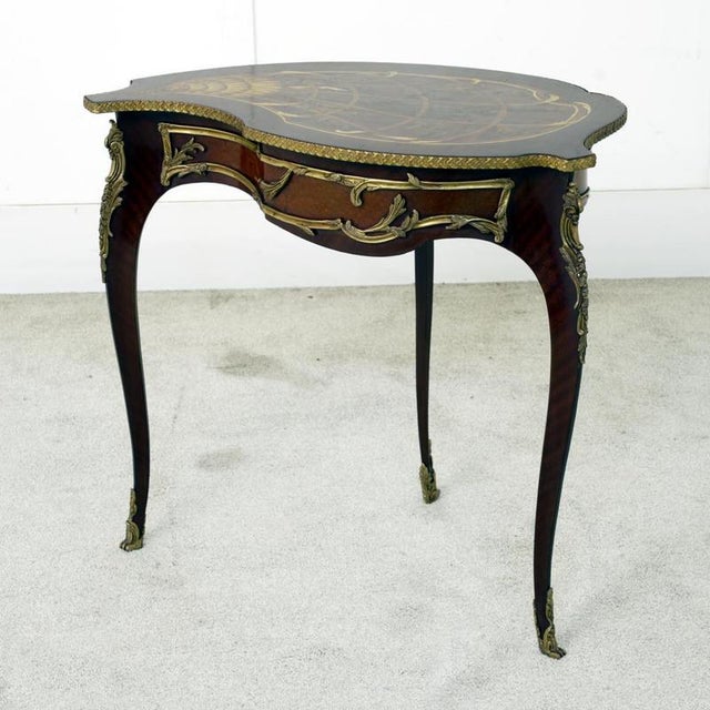 A stunning french side table in the louis xv style, showcasing refined craftsmanship and graceful rococo curves bought...