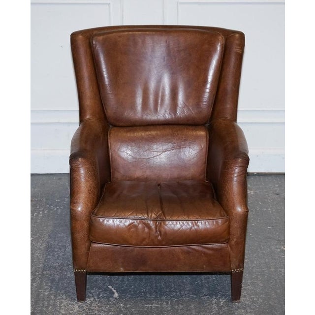 Antiques of London A stylish vintage brown heritage leather reading lounge armchair, designed with a relaxed, club-style...
