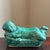 A striking mid-century ceramic Chinese headrest in the form of a reclining child monk finished in a luminous teal glaze....