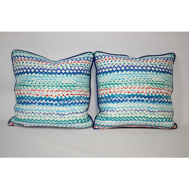 Pair of 20"x20" pillows with new covers and down inserts. Varying hues of blues throughout with a touch of red and a navy...