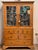 A generous country pine breakfront in one piece, with a dentil and gadrooned cornice above two glazed doors with diamond-...