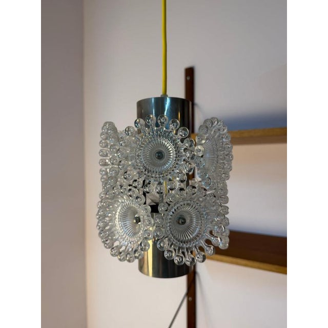A captivating 1970s lighting fixture with playful elegance: this "dandelion" pendant lamp from sölken is a striking homage...