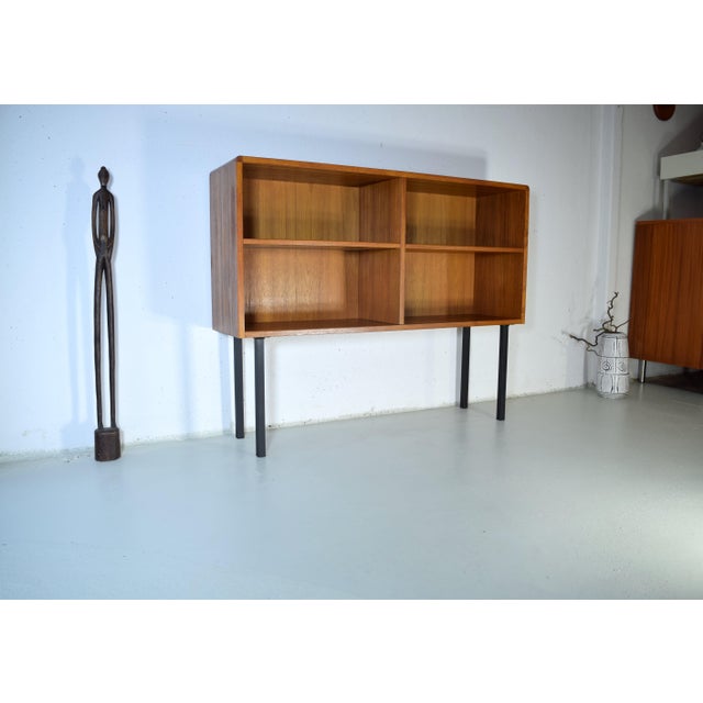 This is a Danish bookcase from the 1960s. The bookcase features a high-quality teak veneer with rounded corners. Both...