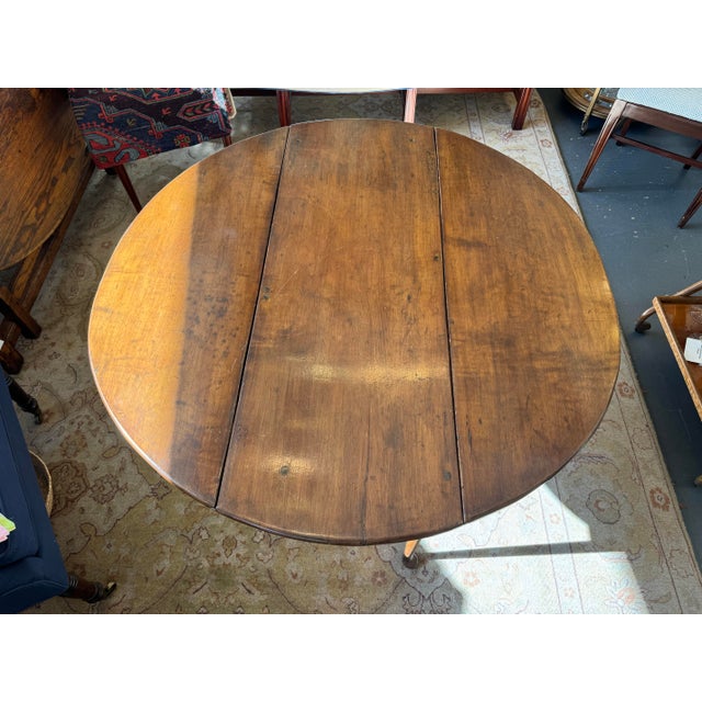 This is a late 18th century American antique drop leaf table. It has a queen Anne style leg. It is walnut wood. It is...