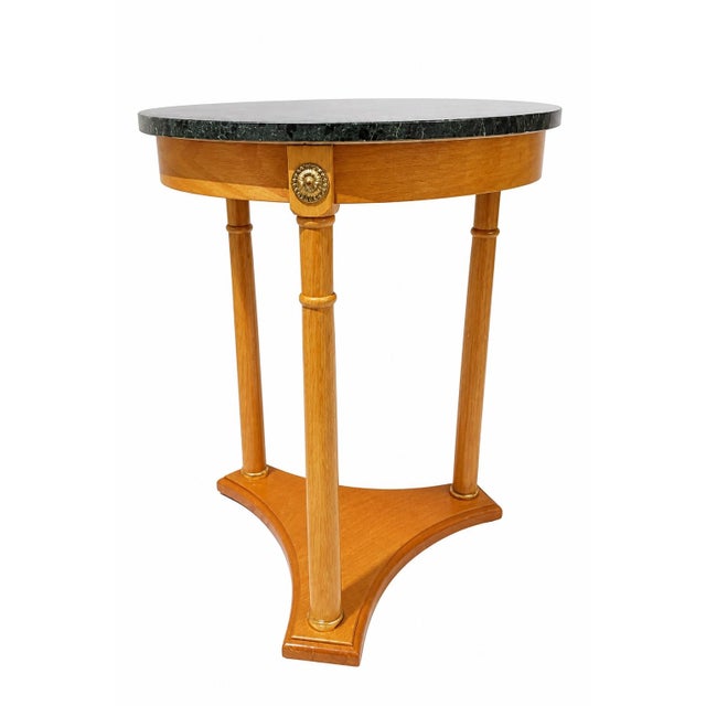 Elegant Empire-style round accent table featuring a substantial dark green marble top set over a warm wood-finished base....