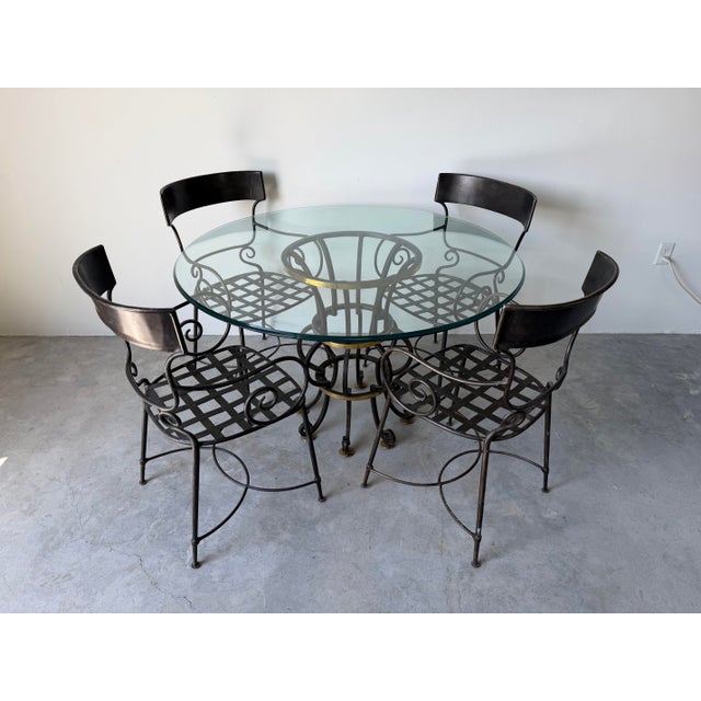 Elegant set of four wrought iron garden dining chairs by Arhaus featuring a sophisticated Hollywood Regency and...