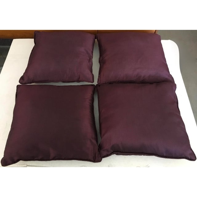 Four beautiful and elegant accent pillows in a deep purple with gold embroidered decoration.