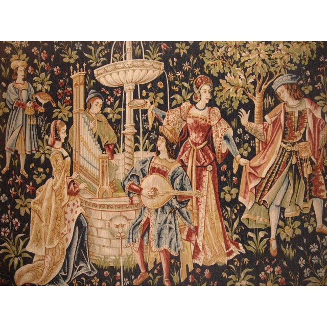 This is a tapestry which is 5' 11 X 4' 1 ft. This medieval scene depicts a concert near a fountain. The background is...