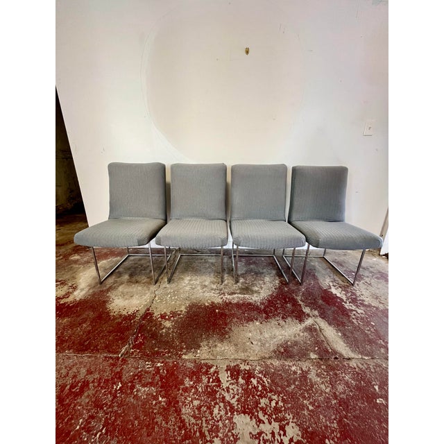 A striking set of four dining chairs by Milo Baughman for Thayer Coggin, featuring architectural polished chrome frames...
