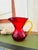 This striking vintage art glass pitcher is attributed to Blenko and features a rich ruby red body paired with a...