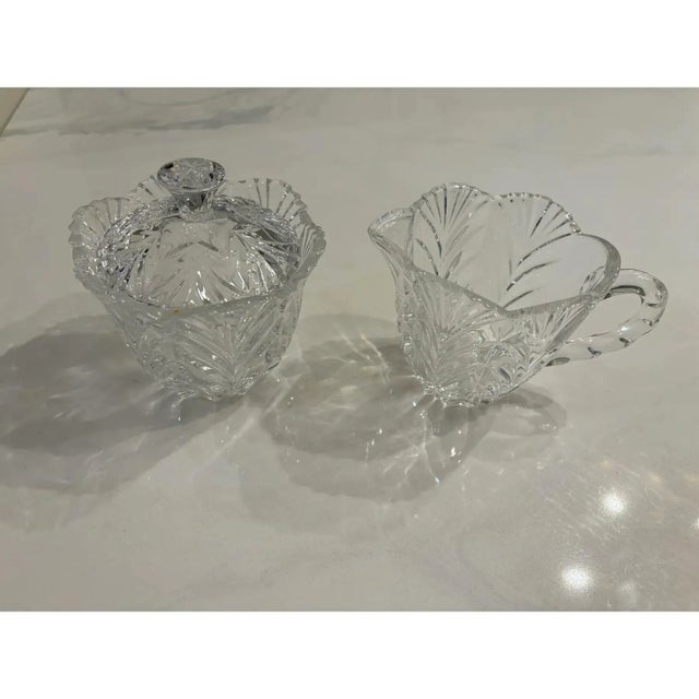 Offered is a vintage set of crystal creamer and sugar bowl set. This set features elegant cut glass with lid for the sugar...