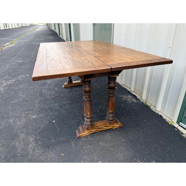 A unique and beautiful rustic oak tavern style dining table. The 6’ long tabletop slides via wooden tracks on the table...