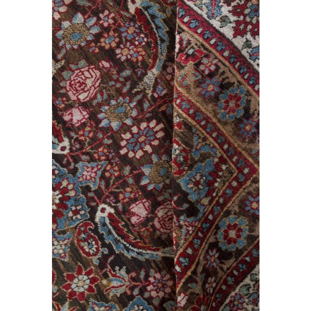 An early 20th century Persian Tabriz antique rug, the dark brown field with an allover herati pattern in red and ice blue...