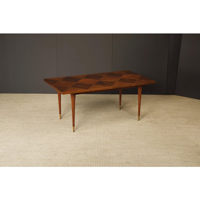 A circa 1950s Tommi Parzinger for Charak Modern extendable dining table crafted with contrasting Mahogany and geometric...