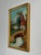 This is a sweet little village landscape on board in its original gold frame. Signed “John Combs” (?) in the lower right...