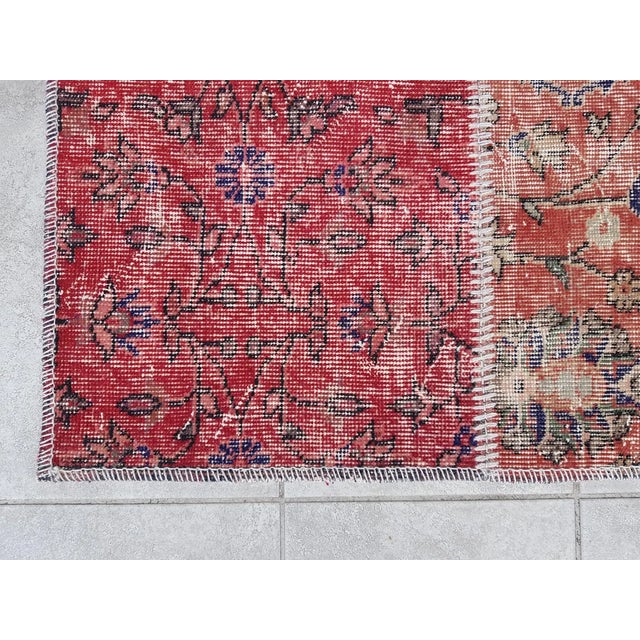 This is a vintage Turkish Oushak rug from the Mid 20th Century. The piece was hand-knotted.