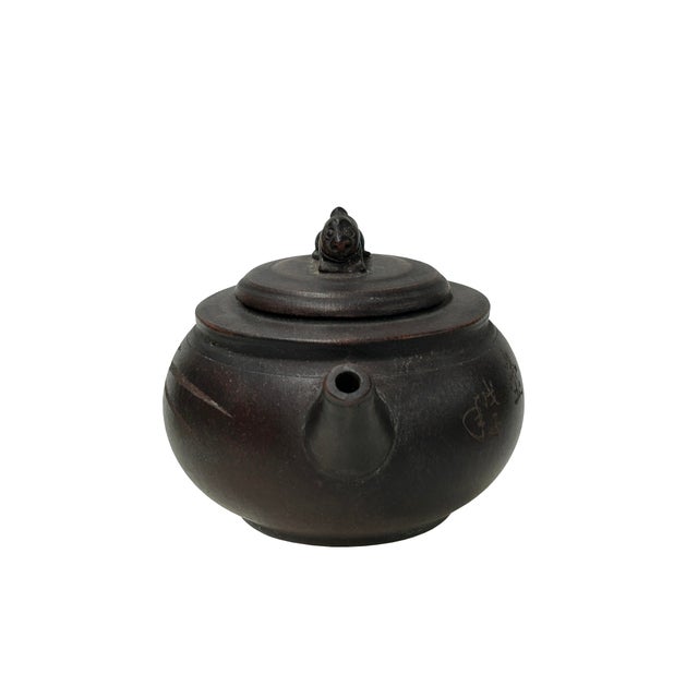 This Chinese Yixing Zisha clay teapot showcases a sophisticated blend of traditional craftsmanship and poetic artistry....