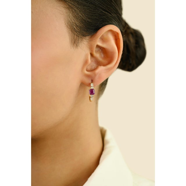 These Hoop Earrings feature 2 square cut rubies totaling 1.99 carats, set in rich 14k yellow gold. Each ruby measures...