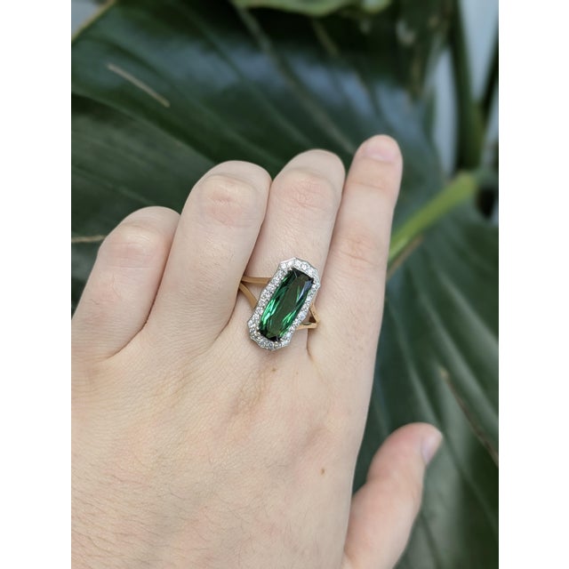 Showcasing a mesmerizing 3.31ct AAA indicolite tourmaline from Brazil, this ring features a striking emerald-cut center...
