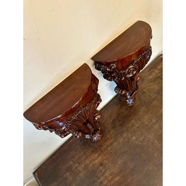 A pair of carved mahogany wall brackets by Maitland-Smith.