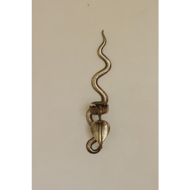 A remarkable pair of brass wall sconces in the Egyptian Revival style featuring a striking single cobra design. This...