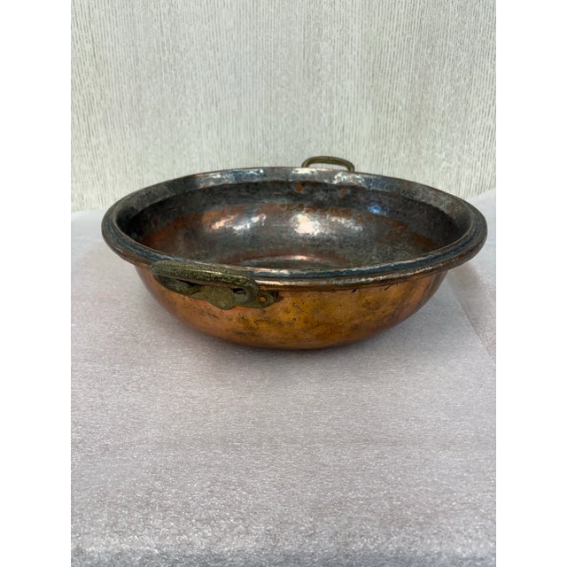 16.5” diameter round flat bottom two handle rustic copper tin lined pot bowl. Hand crafted with hammered surface creating...