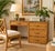 This 1970s Vintage Boho Coastal Rattan Writing Desk features intricate craftsmanship in a warm, natural honey finish....