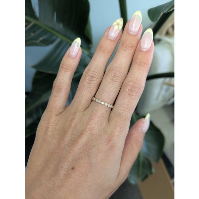 This elegant diamond band features a refined row of sparkling diamonds set in solid 14K gold, accented with delicate...